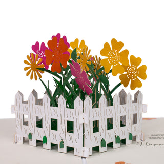 Close-up of the colorful flower garden surrounded by a white fence details in the flower garden birthday pop-up card.