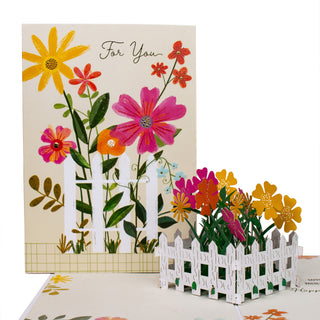 Open flower garden birthday pop-up card showing the colorful flower garden surrounded by a white fence at an angle.